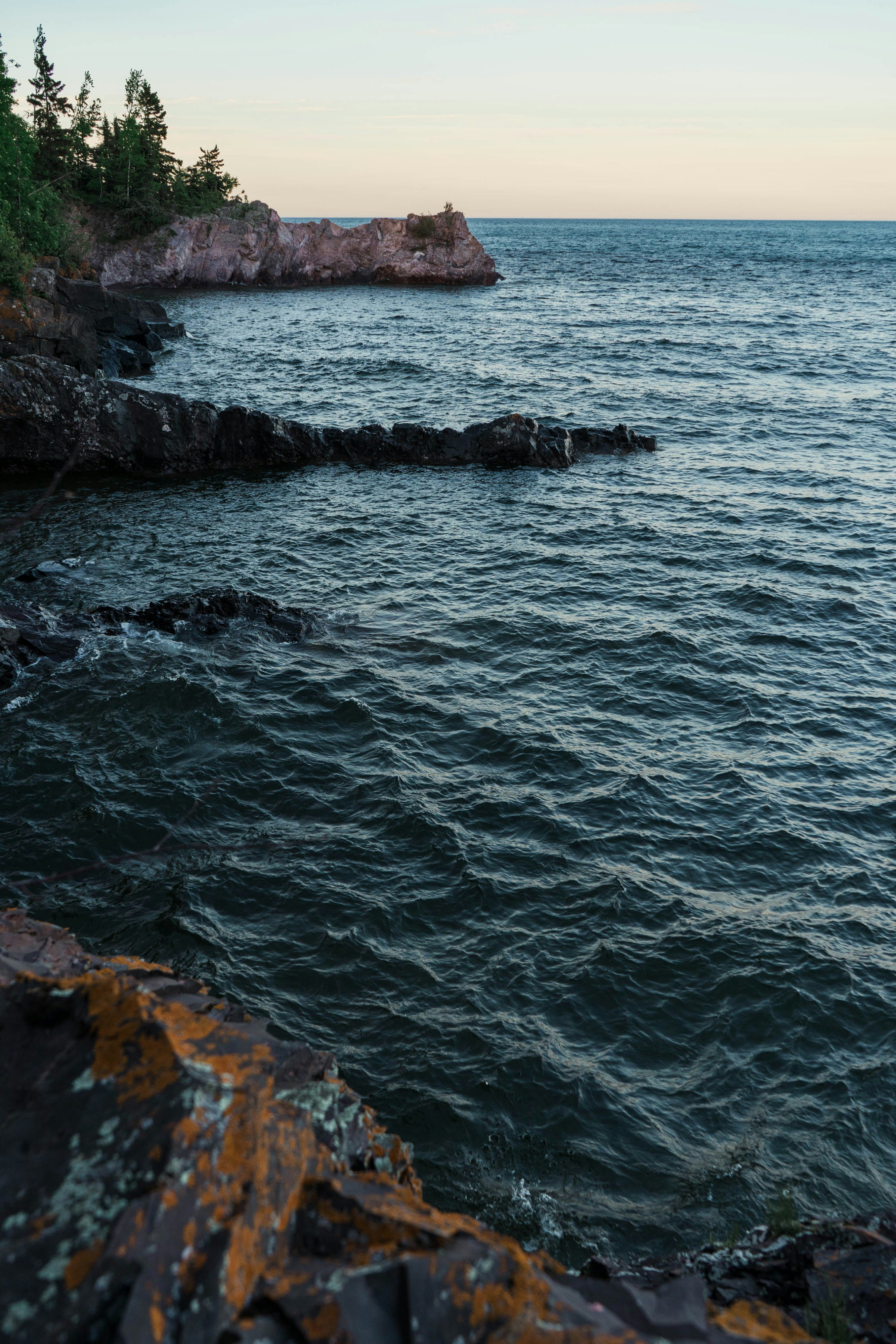 body of water near green trees during daytime